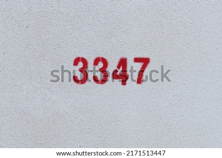 Red Number 3347 on the white wall. Spray paint.
