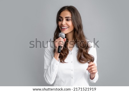 Woman speech, business woman holding a microphone. Young business woman talking with mic. Woman talking with microphone. Communication and information concept.