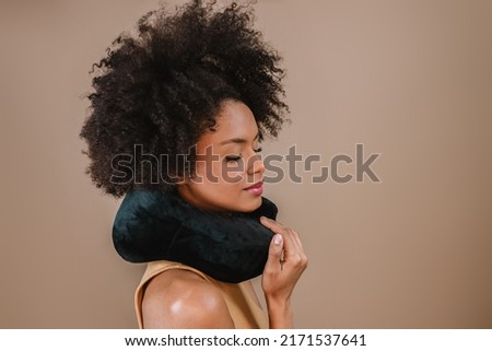 Young handsome Latin woman pillow neck travel abroad flight comfort isolated over pastel brown color background Royalty-Free Stock Photo #2171537641