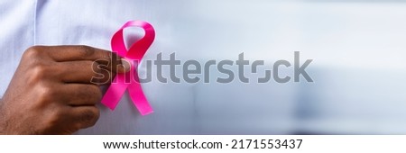 Man's Hand With Pink Ribbon Supporting Breast Cancer Cause Royalty-Free Stock Photo #2171553437
