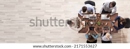 Elevated View Of Businesspeople Using Laptop And Digital Tablet In Office Over Wooden Desk Royalty-Free Stock Photo #2171553627