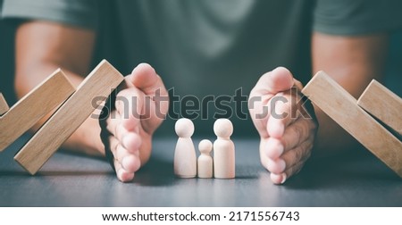 The young man used both of his hands to protect from the falling wooden blocks.,The concept of caring, protecting, protecting family members to be safe and happy. Royalty-Free Stock Photo #2171556743