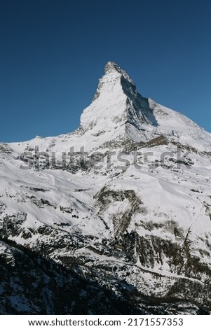 Scenic view of snowy Matterhorn mountain peak in sunny day with blue sky in Switzerland. Soft and blur focus.
