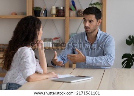 Latino male company position candidate answers questions during job interview in office, female recruiter listen to applicant. Staffing, business meeting of client and manager, human resources concept Royalty-Free Stock Photo #2171561101