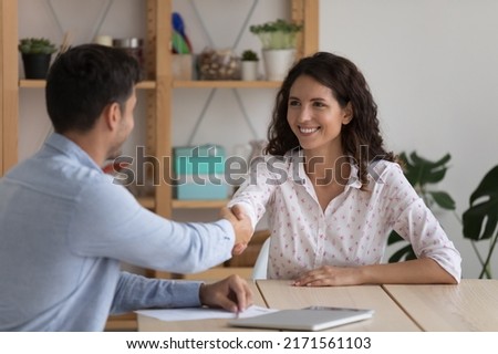 Client and sales manager handshaking after closing profitable deal in company office, recruitment concept. Attractive Hispanic position candidate and HR manager shaking hands after successful hiring Royalty-Free Stock Photo #2171561103
