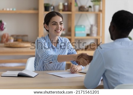 Closing deal, successful negotiations, business cooperation, job interview, HR concept. Diverse businesspeople sit at desk make decision, sign contract, handshake accomplish meeting feeling satisfied