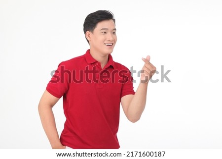 Asian a man handsome young smiling happy showing heart-shaped hands gesture and the side eyes looking at camera in love isolated on pink blank copy space studio background