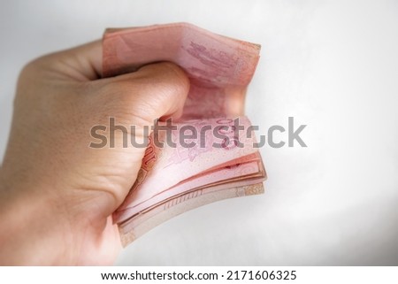 Thai banknotes in the hands of a man Royalty-Free Stock Photo #2171606325