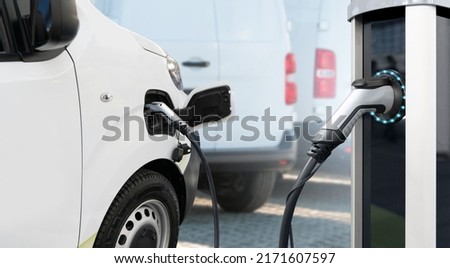 Electric delivery van with electric vehicles charging station.  Royalty-Free Stock Photo #2171607597
