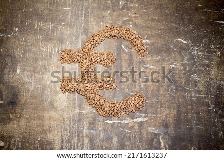Buckwheat grains in the form of a euro sign. Rise in the cost of food due to the war in Ukraine