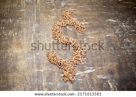 Buckwheat grains in the form of a dollar. Rise in the cost of food due to the war in Ukraine Royalty-Free Stock Photo #2171613581