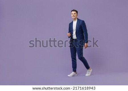 Full size body length young successful employee business man lawyer 20s wear formal blue suit white t-shirt work in office move stroll look aside isolated on pastel purple background studio portrait Royalty-Free Stock Photo #2171618943