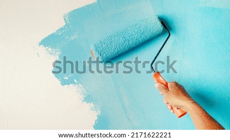  painting interior wall with paint roller  Royalty-Free Stock Photo #2171622221