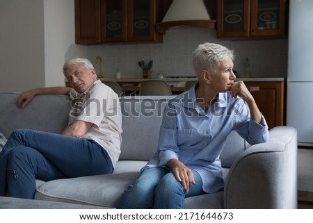 Thoughtful older married couple sit on sofa separately, feeling frustrated looking upset after quarrel. Misunderstanding between mature spouses, crisis in relationships, difficulties, jealousy concept Royalty-Free Stock Photo #2171644673