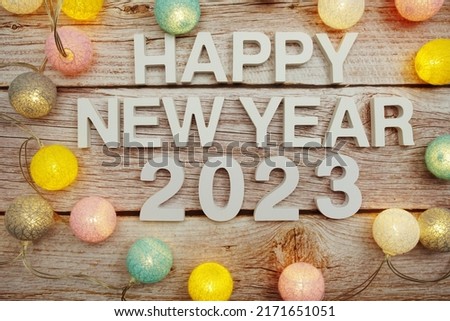Happy New Year 2023 alphabet letter decorate with LED cotton balls on wooden background