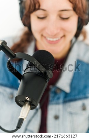 Close up view of woman smiling with microphone in front of face