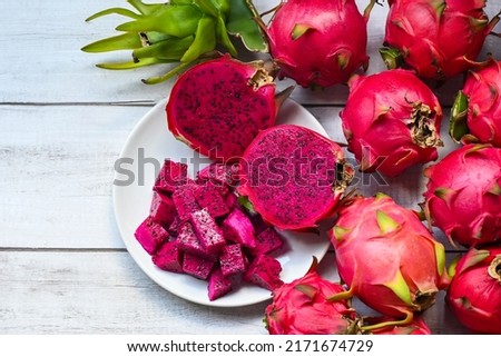 dragon fruit slice and cut half on white plate with pitahaya background , fresh red purple dragon fruit tropical in the asian thailand healthy fruit concept - top view