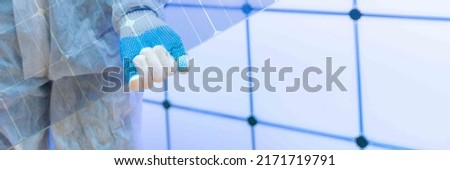 Translucent solar panels for use as window glass. Photovoltaic glass is  most cutting-edge new solar panel technology that   scope of solar. Transparent solar panel in the hands of a worker Royalty-Free Stock Photo #2171719791