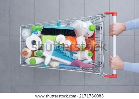 Customer pushing a shopping cart full of cleaning products and housekeeping equipment, top view Royalty-Free Stock Photo #2171736083