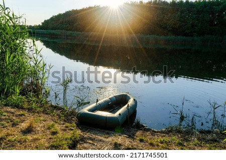 Inflatable boat on the river bank. Preparation for fishing. Background. A series of pictures.