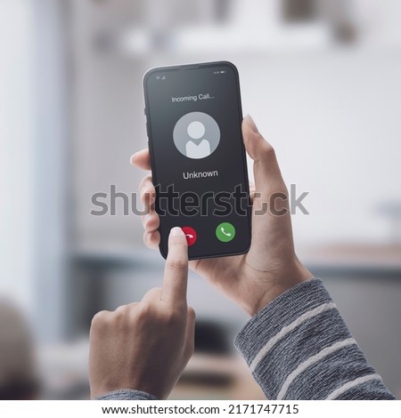 Woman receiving a call on her smartphone from an unknown number, malicious phone calls concept Royalty-Free Stock Photo #2171747715
