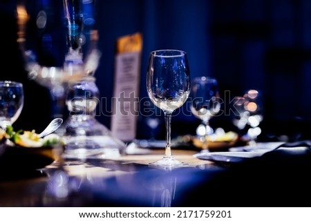 Luxury table settings for fine dining with and glassware, pouring wine to glass. Beautiful blurred background. Preparation for holiday wedding. Fancy luxury restaurant. Royalty-Free Stock Photo #2171759201