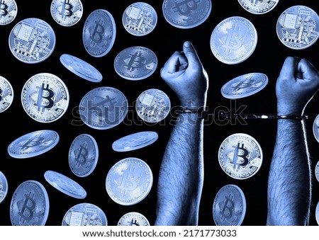 Bitcoins and male hands in handcuffs over dark background