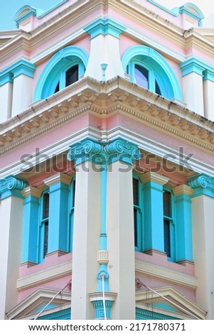 Pastel painted façade of heritage building with raised pilasters fitted with Ionic capitals on the Albert and Queen streets corner in the CBD-central business district. Brisbane-Queensland-Australia.