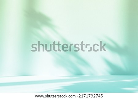 Abstract gradient green studio background for product presentation. Empty room with shadows of window and flowers and palm leaves . 3d room with copy space. Summer concert. Blurred backdrop. Royalty-Free Stock Photo #2171792745