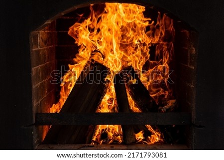 burning firewood in a stone fireplace with a hot flame