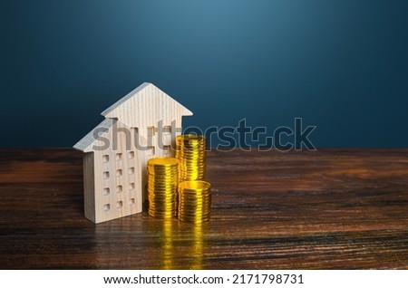 Houses and golden coins. Savings on household bills. Energy efficiency and energy saving. Profit from investment in housing. Municipal budget for the maintenance of buildings. Price cost estimate Royalty-Free Stock Photo #2171798731