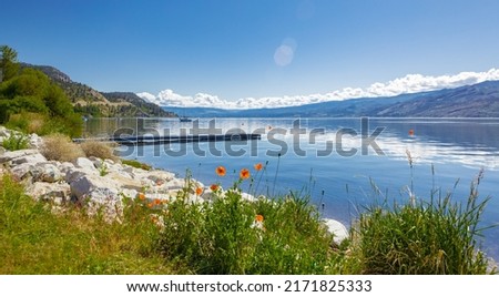 Okanagan Lake Canada. Summer landscape of a lake and mountains in the background in early morning. Concept relaxation. Perfect spot for tourists and quiet nature walks. Travel photo, nobody, copyspace Royalty-Free Stock Photo #2171825333