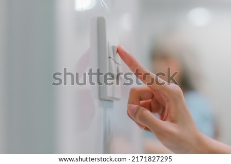 Hand turning off on light switch. Royalty-Free Stock Photo #2171827295