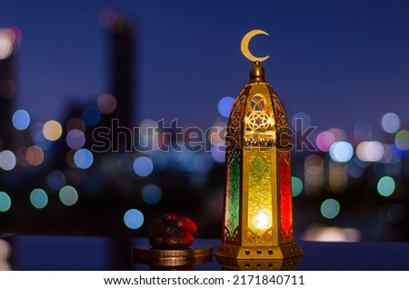 Lantern that have moon symbol on top and small plate of dates fruit for the Muslim feast of the holy month of Ramadan Kareem and Islamic new year concept. Royalty-Free Stock Photo #2171840711