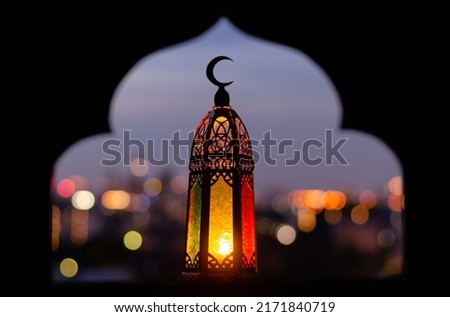 Lantern that have moon symbol on top with blurred focus of paper cut for mosque shape background. Ramadan Kareem and Islamic new year concept. Royalty-Free Stock Photo #2171840719