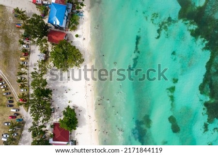 Top view of a moderately crowded public beach in Anda, Bohol, Philippines.