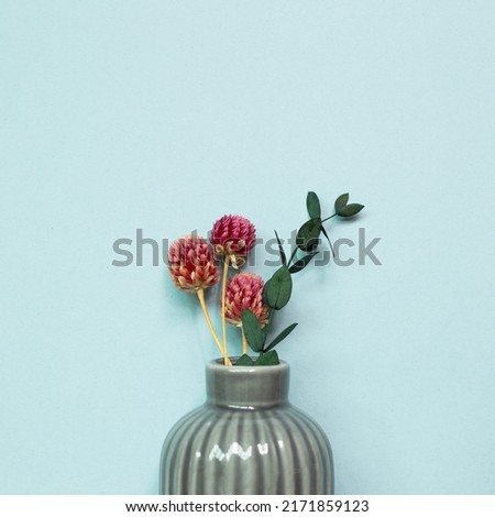 Vase of dry flowers on blue background. top view, copy space