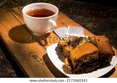 chocolate cake with a cup of tea on wooden board. breakfast menu in the morning 