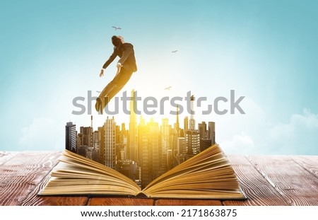 Businessman in suit running on top of a book