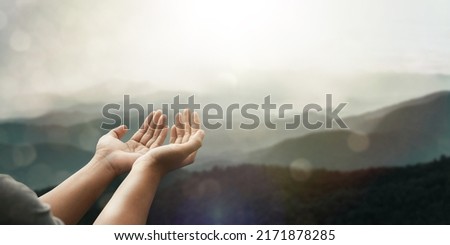 The two hands of a young man who prayed for hope from God Praise God concept. Pray, communicate. Mountain nature background. at sunrise Royalty-Free Stock Photo #2171878285