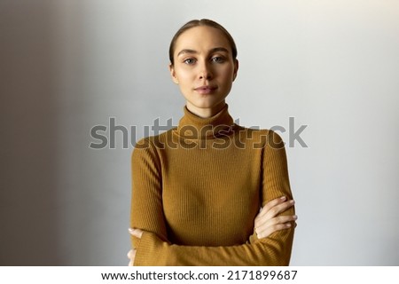 Successful confident woman in turtleneck holding arms crossed looking at camera with decisive, friendly and bossy facial expression, standing determined and self-assured against white background Royalty-Free Stock Photo #2171899687