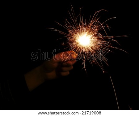 hand with sparkler on a black background