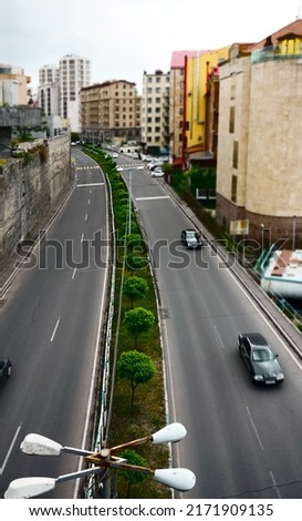 Top view grey asphalt highway with moving vehicles and green grass roadside. Yerevan, Armenia. 