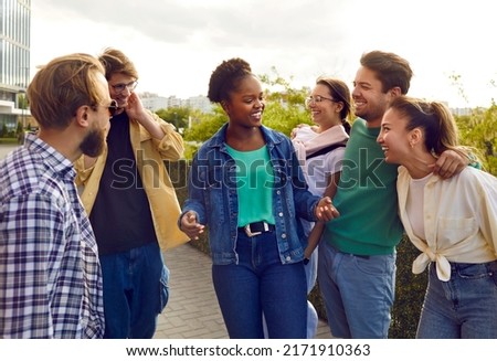 Bunch of joyful diverse college friends meet up in the city. Group of happy beautiful young multi ethnic Caucasian, Afro American and Asian people standing on the street, chit chatting and laughing Royalty-Free Stock Photo #2171910363