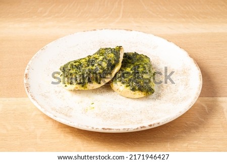 chicken chop with spinach on a plate on a light wooden background Royalty-Free Stock Photo #2171946427