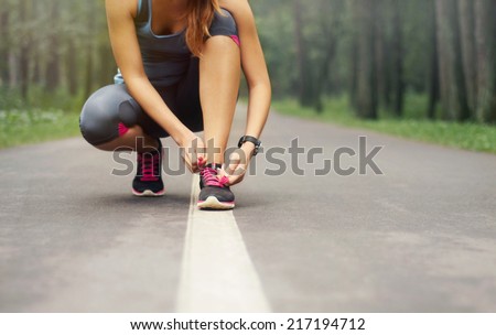 young sporty woman preparing to run in early foggy morning in the beautiful nature forest, wellness concept Royalty-Free Stock Photo #217194712