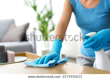 Woman cleaning a wooden table at home, hygiene and housekeeping concept, hands close up Royalty-Free Stock Photo #2171950211