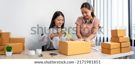 Two woman small business entrepreneur working at home receive ordering from online customer and checking data while preparing to packing product deliver sending to client. Royalty-Free Stock Photo #2171981851