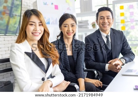 Group of young business people working, communicating while sitting at the office desk together with colleagues. Business people has stategic planning in office. Business concept.
