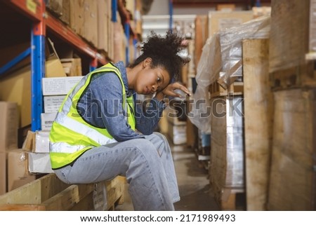 Tired stress woman worker labor working in warehouse cargo inventory industry. Royalty-Free Stock Photo #2171989493